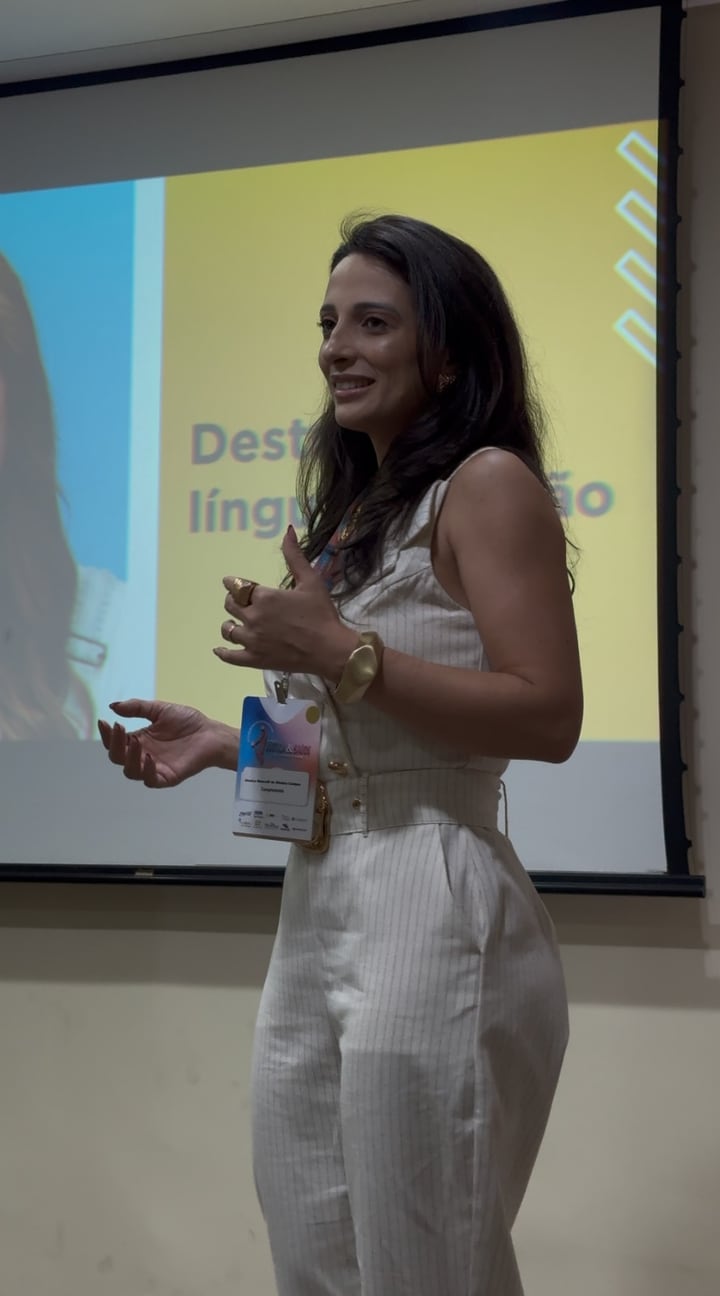 Jéssica Marcelli apresentando uma palestra diante de uma tela